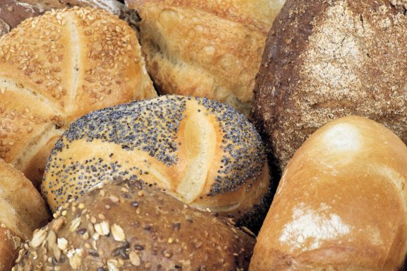 Verschiedene Brotsorten, darunter Brötchen mit Körnern und unterschiedliche Krusten.