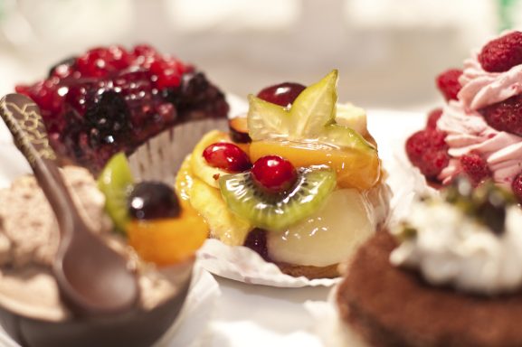 Bunte Auswahl an Desserts mit Früchten, Sahne und Schokoladenstückchen.