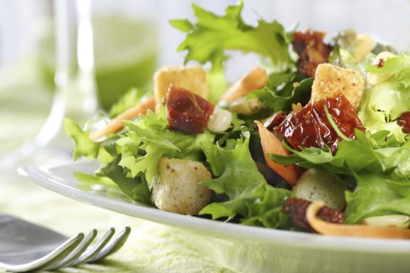 Frischer Salat mit Croutons, getrockneten Tomaten und buntem Gemüse.