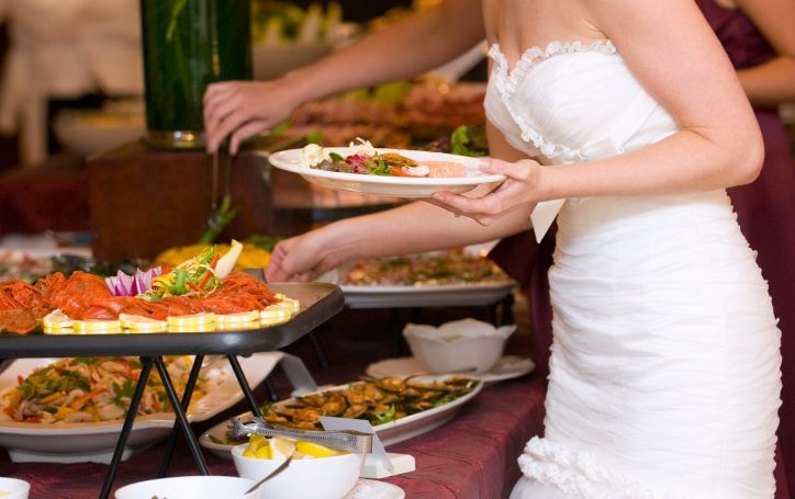Braut am Hochzeitsbuffet in Berlin | Al-Layal Catering. Braut in weißem Kleid vor dem Hochzeitsbuffet von Al-Layal in Berlin.